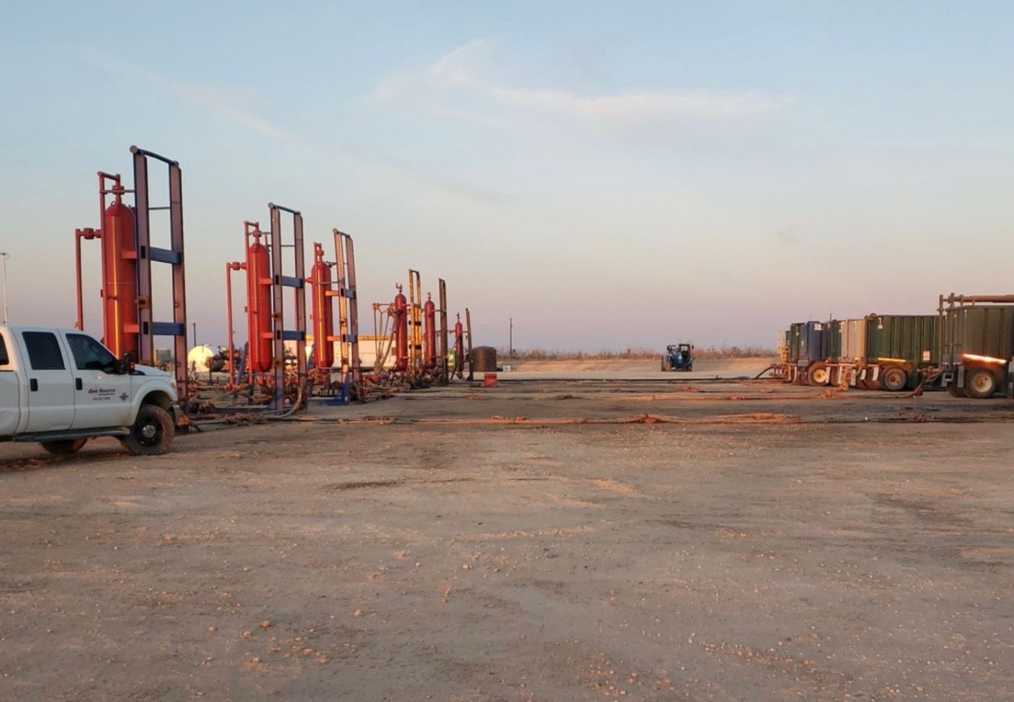Industrial site with large red equipment under a clear sky.